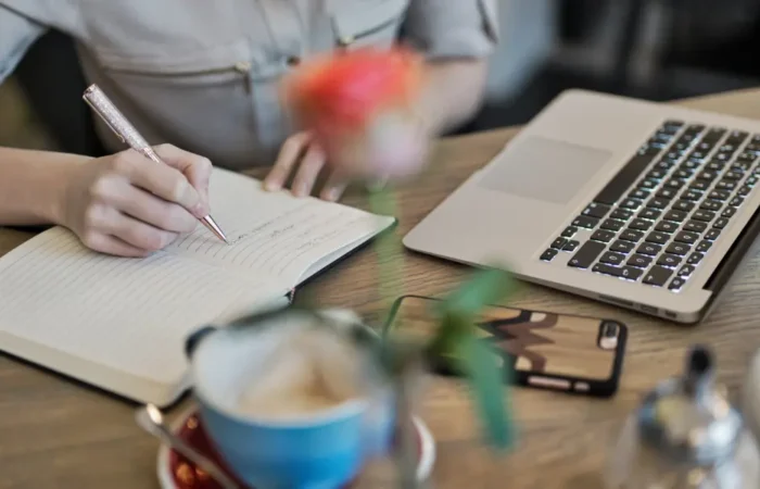 a picture of a person writing in a notebook to plan thier content curation