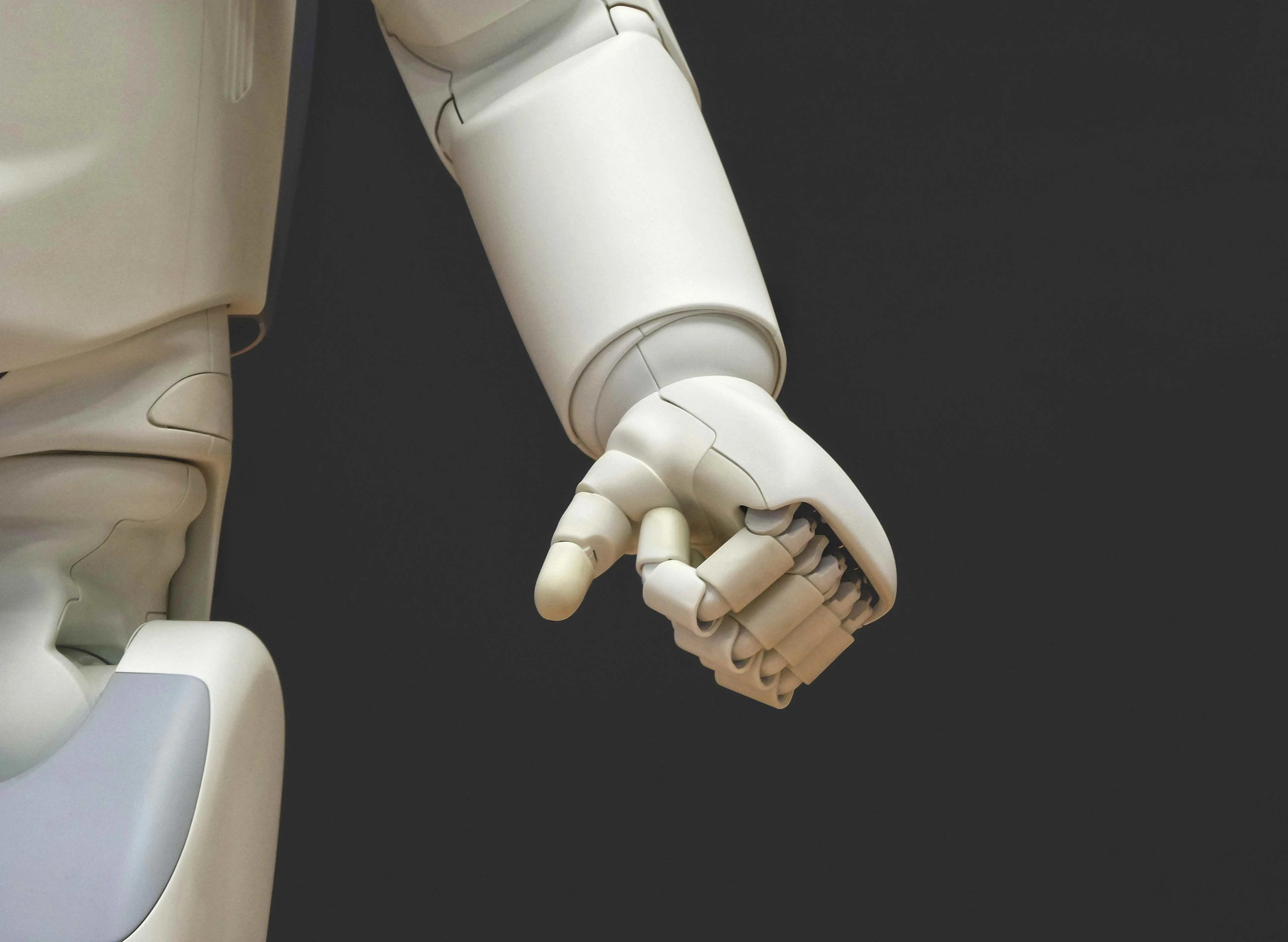 a white robot arm with the hand in a fist position