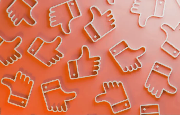 photo shows a bunch of thumbs up emojis in a pattern on an orange background