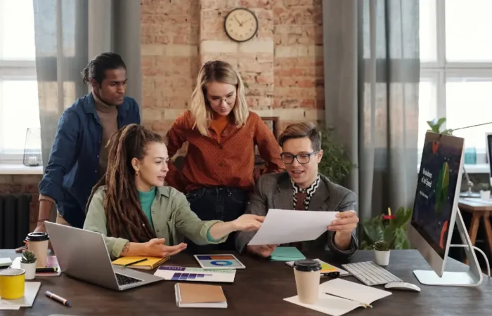 a group of people around a desk looking at a marketing funnel diagram