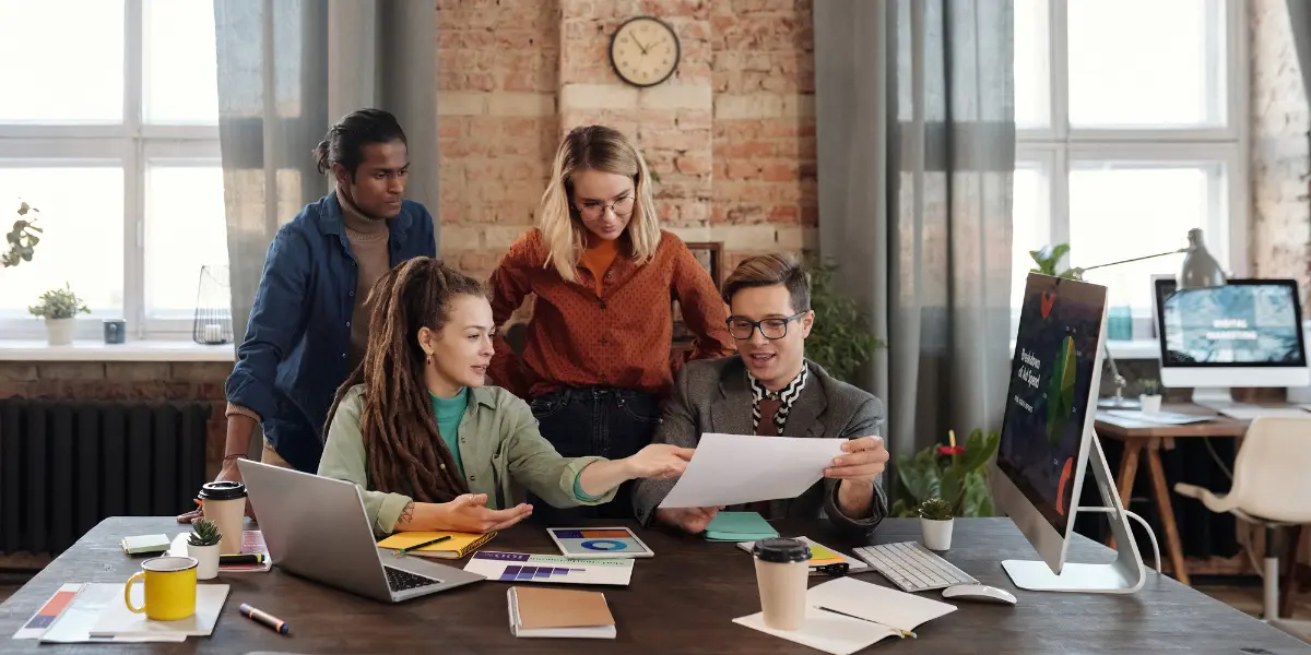 a group of people around a desk looking at a marketing funnel diagram